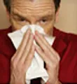 Man sneezing into tissue