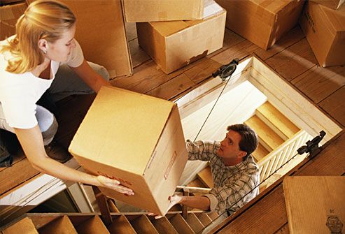 Couple moving clutter into attic