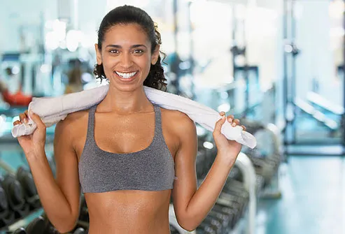 Young woman holding towel in gym