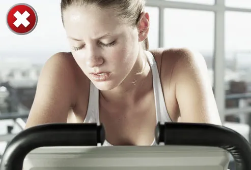 Young woman leaning on exercise machine