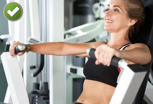 Woman using chest press machine at gym