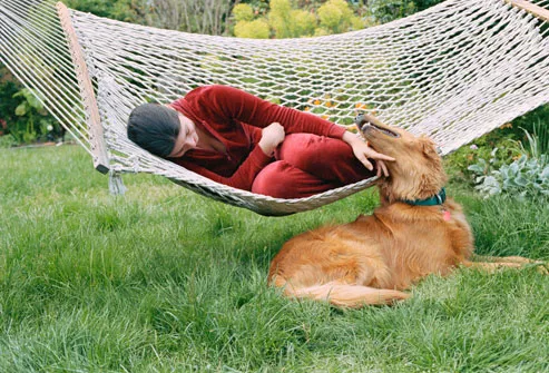 Woman on hammock petting dog