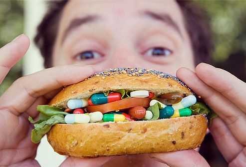 Man eating sandwich of pills and capsules
