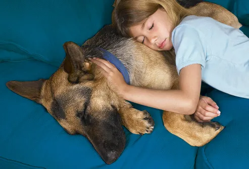 Young Girl Laying Next To Dog