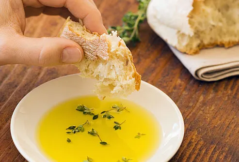 Man dipping bread in olive oil
