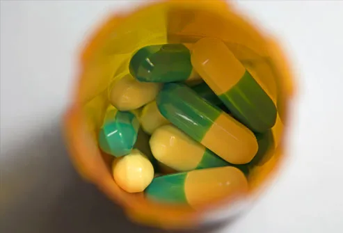 Prescription filled with green and yellow pills