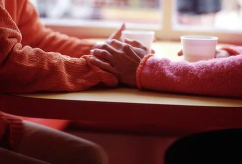 women holding hands in cafe