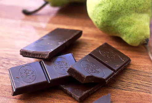 Squares of dark chocolate with two pears behind