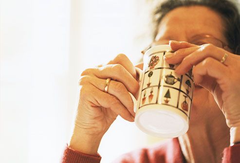 Mature woman drinking hot drink, close-up
