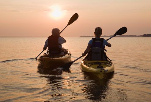 Couple Kayaking Into Sunset