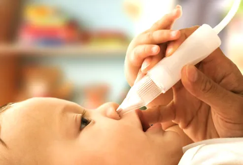 Mother suctioning babys nose