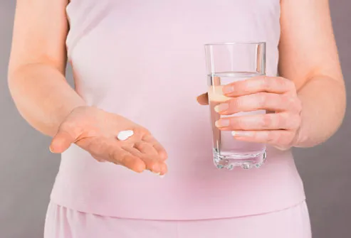 Woman Holding Pill and Water