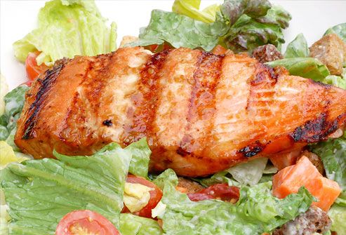 Grilled salmon on a plate of salad