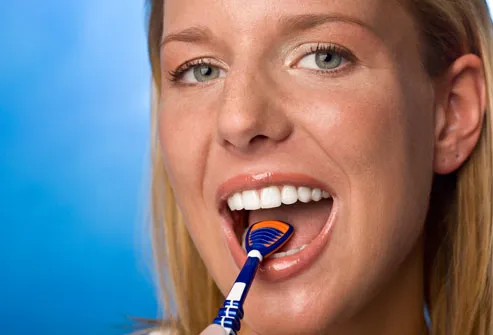 Woman using tongue scraper