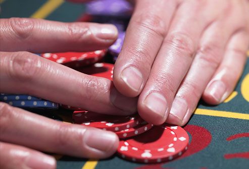 Man gathering pile of chips at roulette table