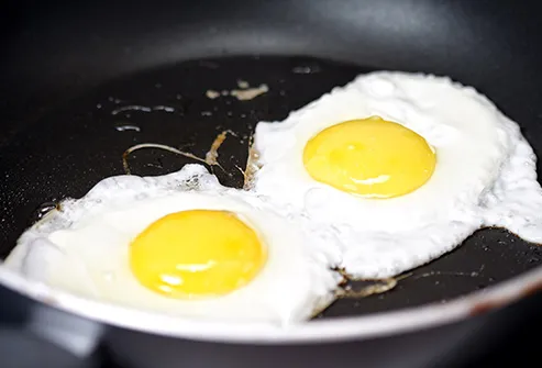 two eggs frying in pan