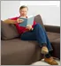man reading book on couch