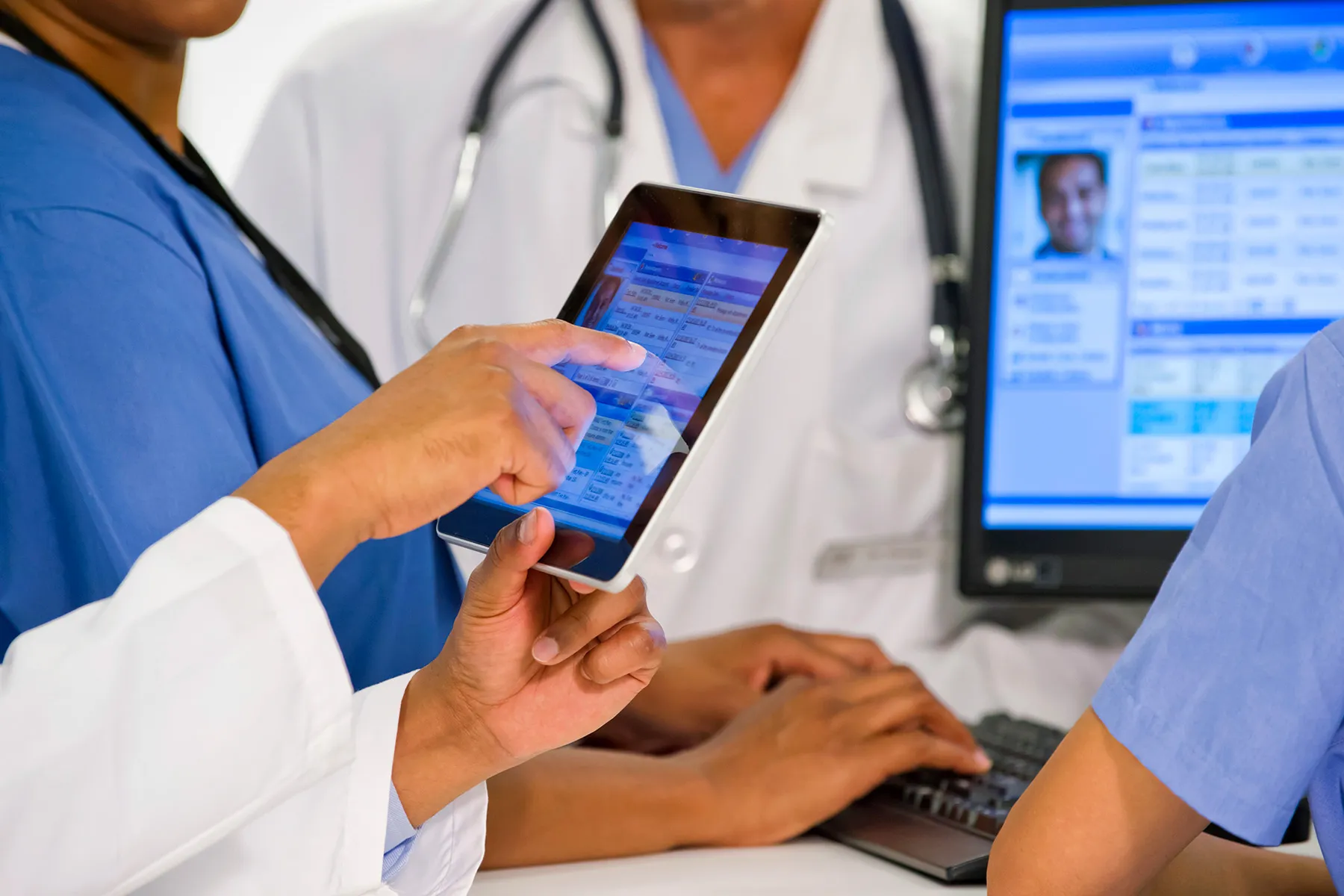 photo of doctors using digital tablet in hospital
