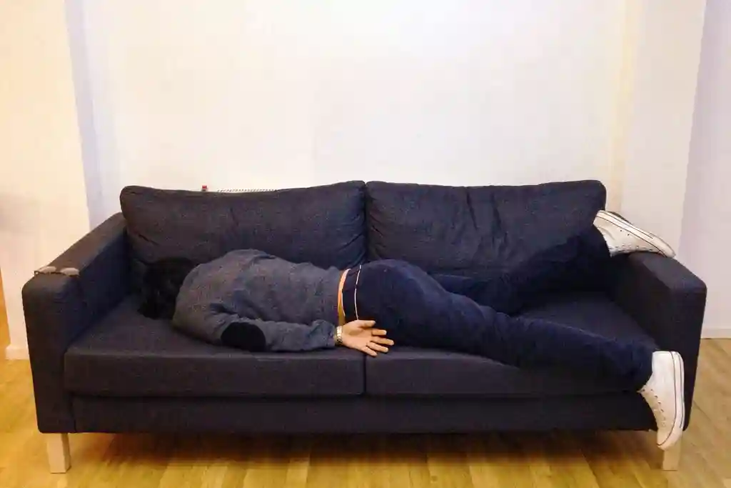 photo of man asleep on sofa at home