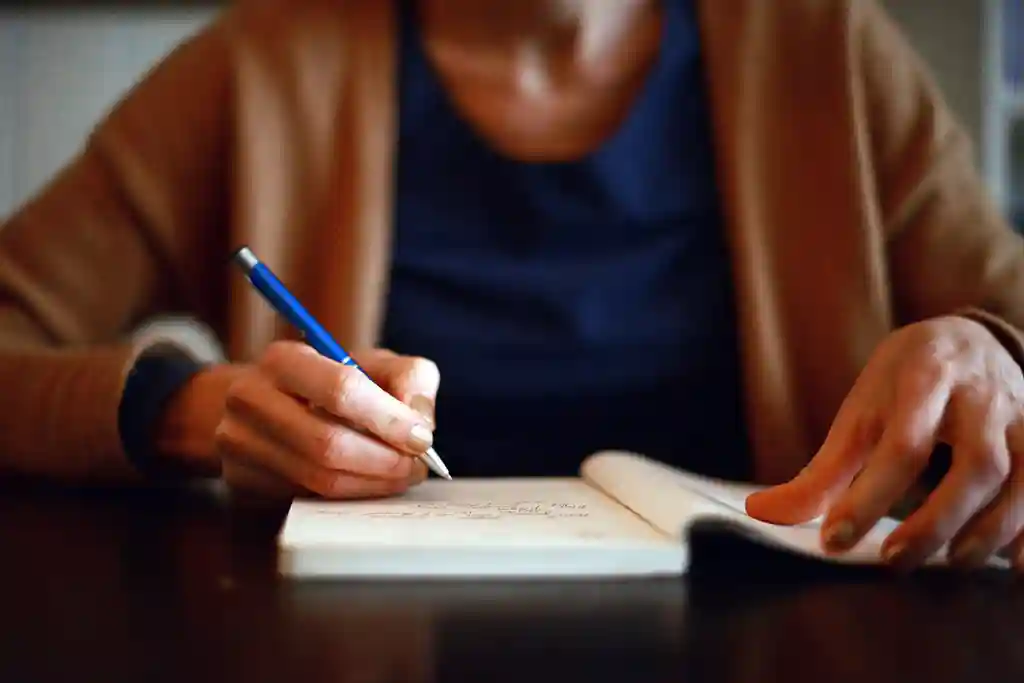 photo of woman writing in a notebook