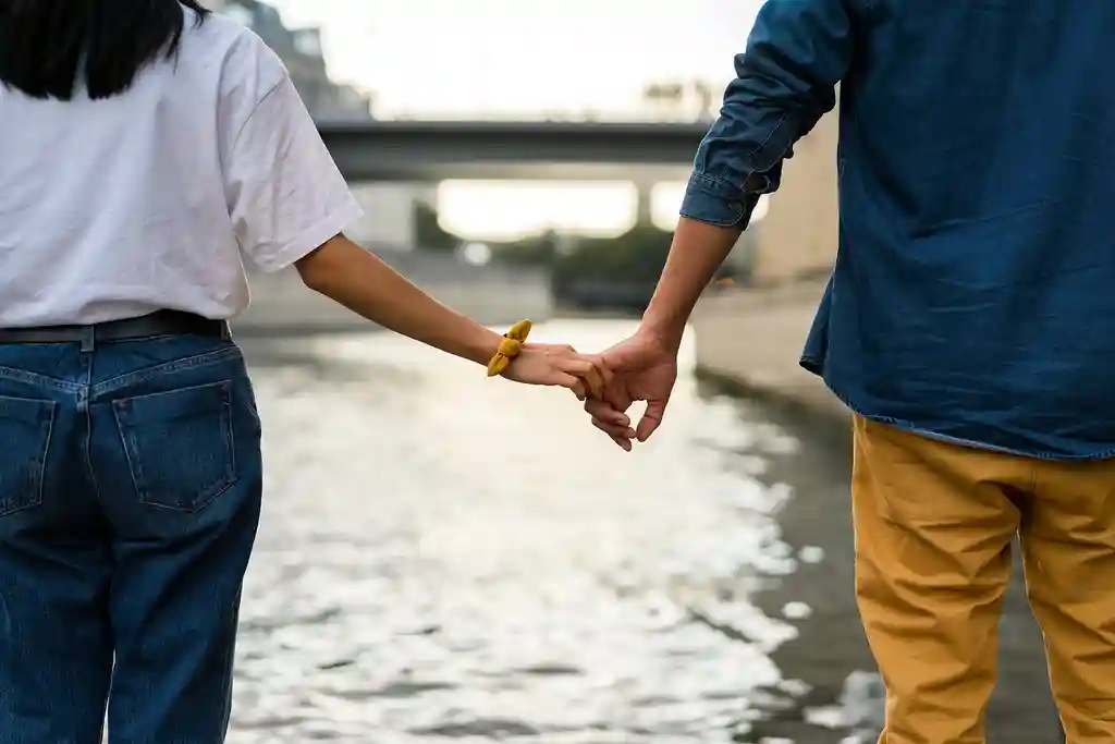 photo of couple holding hands by the river Seine