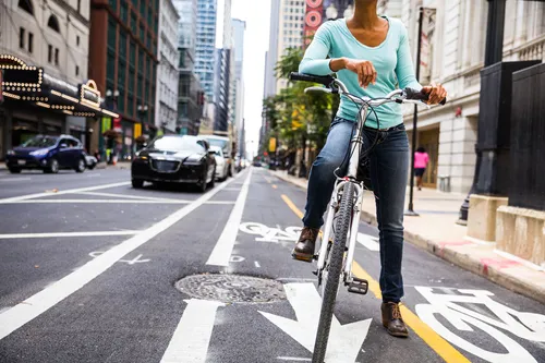 photo of woman biking in city