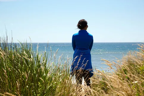 photo of woman looking at ocean