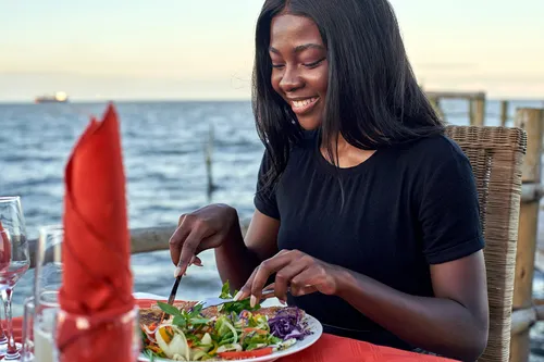 photo of woman enjoying waterfront dinner
