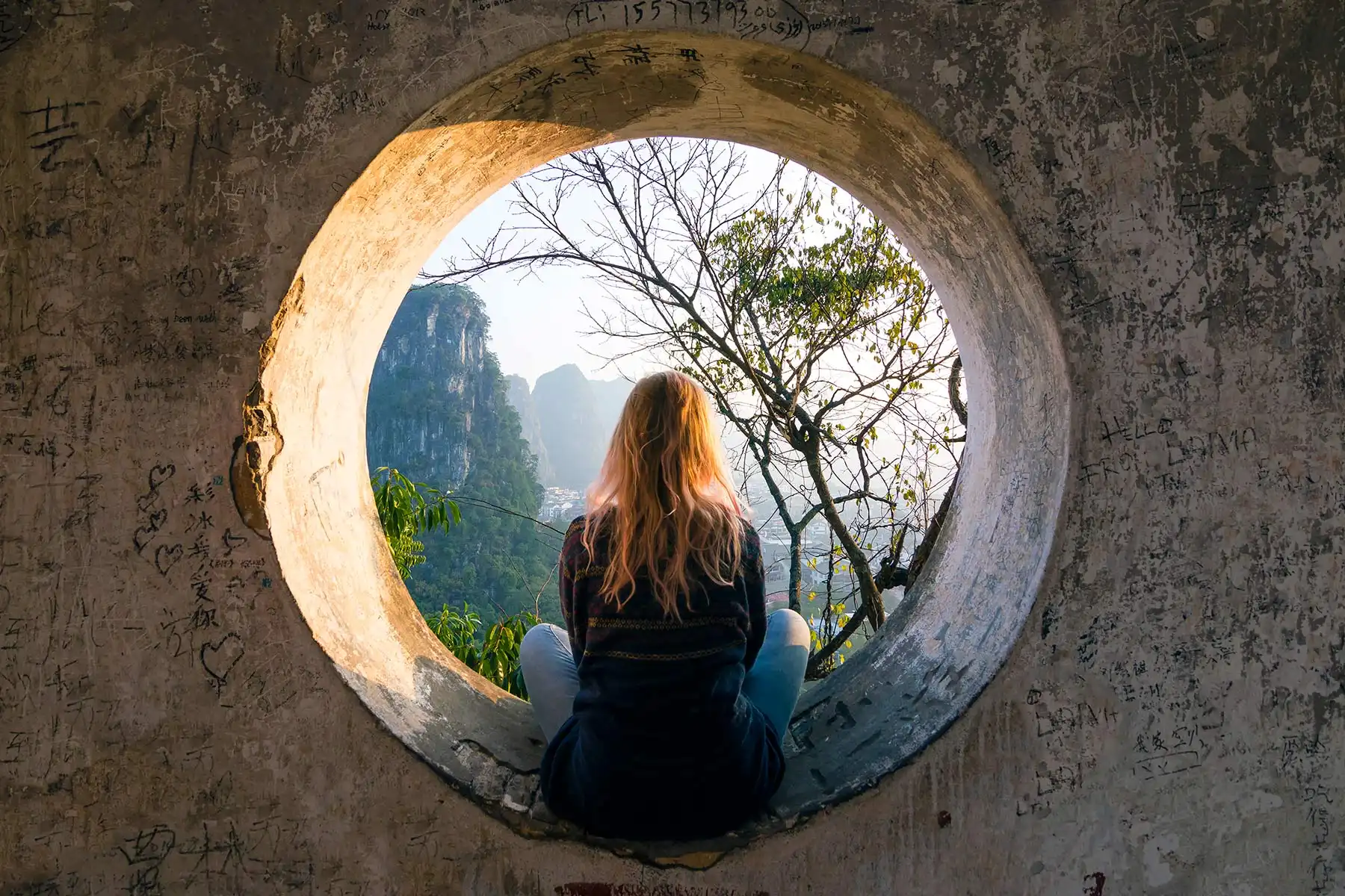photo of woman viewing landscape through circular 