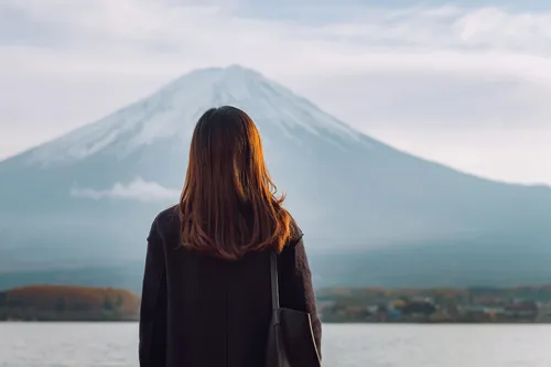 photo of rear view of woman looking at mount fuji