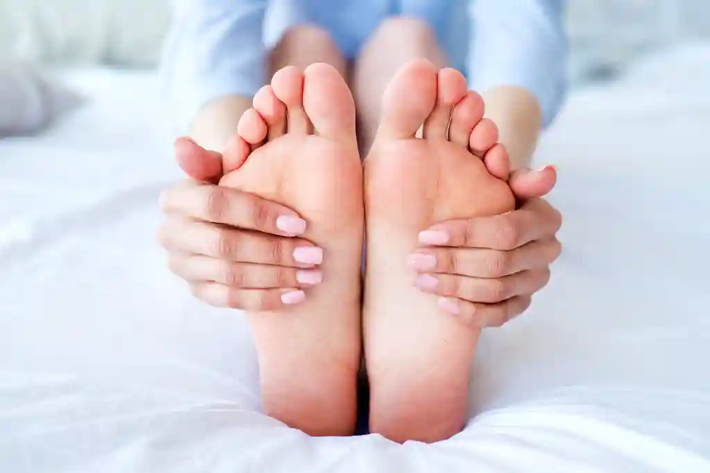 photo of woman massaging her feet