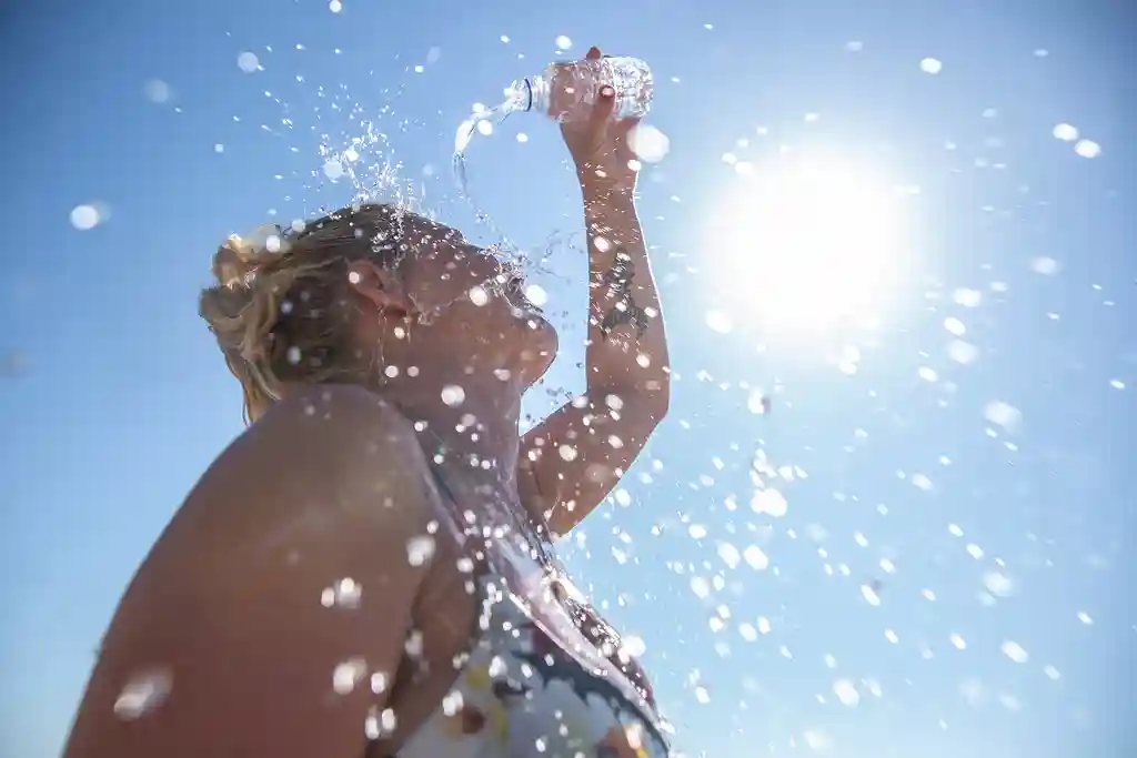 photo of young woman cooling down with cold water