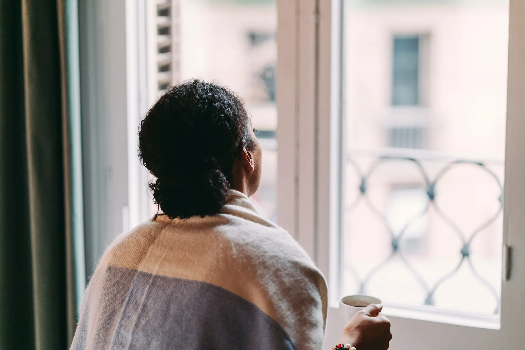 photo of woman looking out window