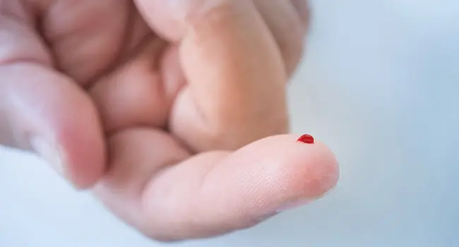 finger with drop of blood