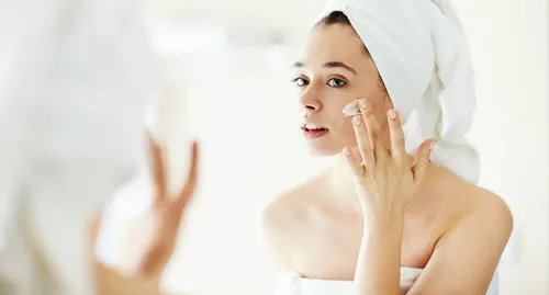 woman applying lotion on face