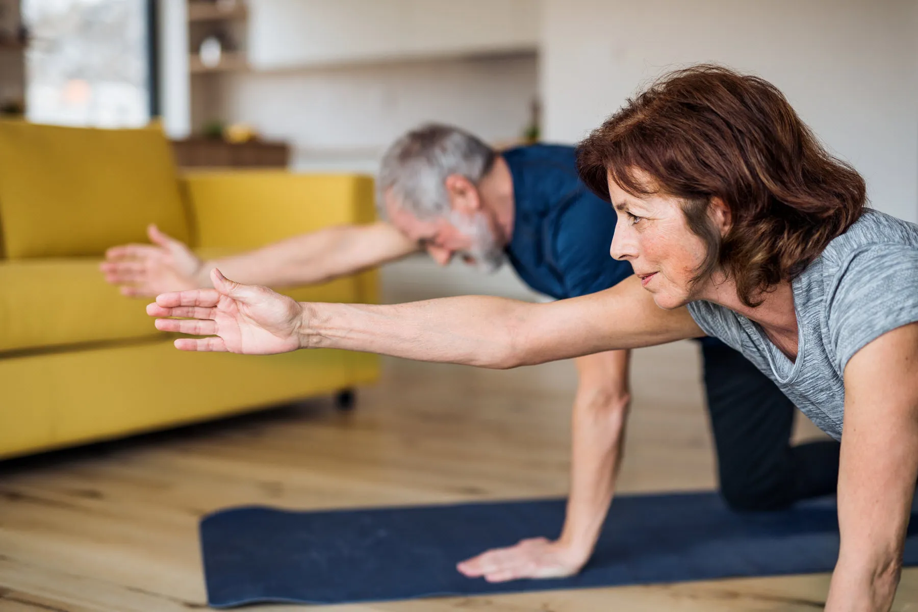 older couple doing yoga at home