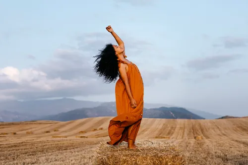 photo of woman dancing in field