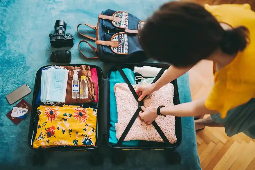 photo of young woman packing suitcase