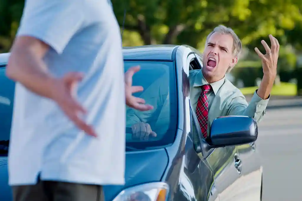 photo of man in car yelling at pedestrian