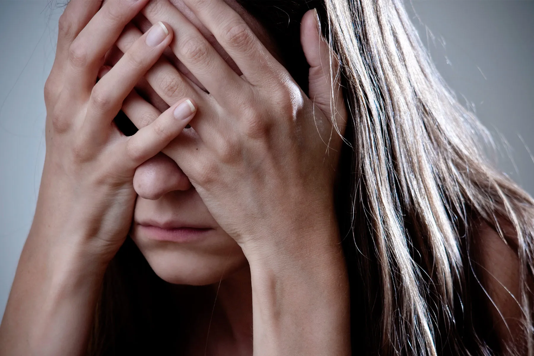 photo of depressed woman with head in hands