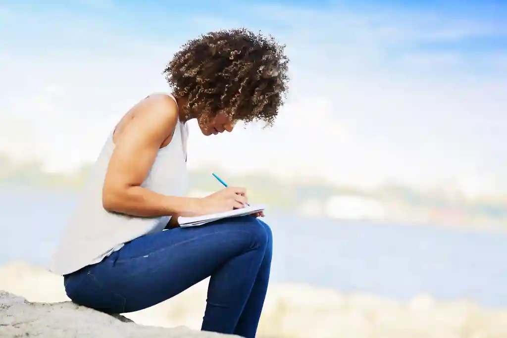 photo of woman writing in notebook