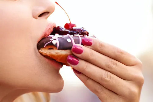photo of  woman eating donut close-up