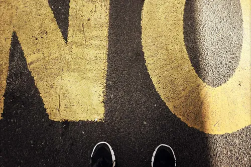 photo of feet in front of no sign on the street