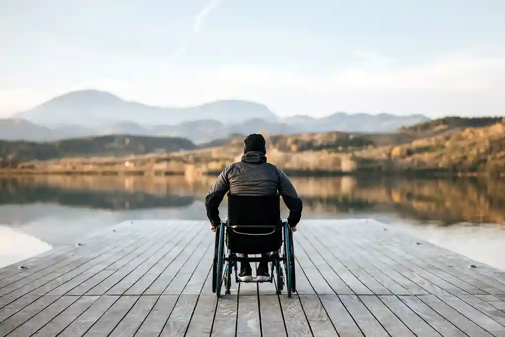 坐轮椅的男子欣赏湖泊的照片