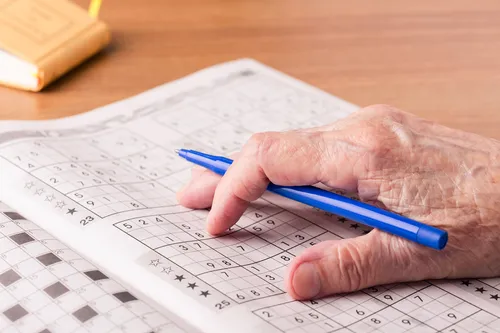 photo of senior woman playing sudoku