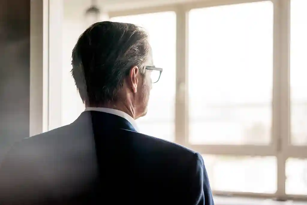 photo of businessman looking out window