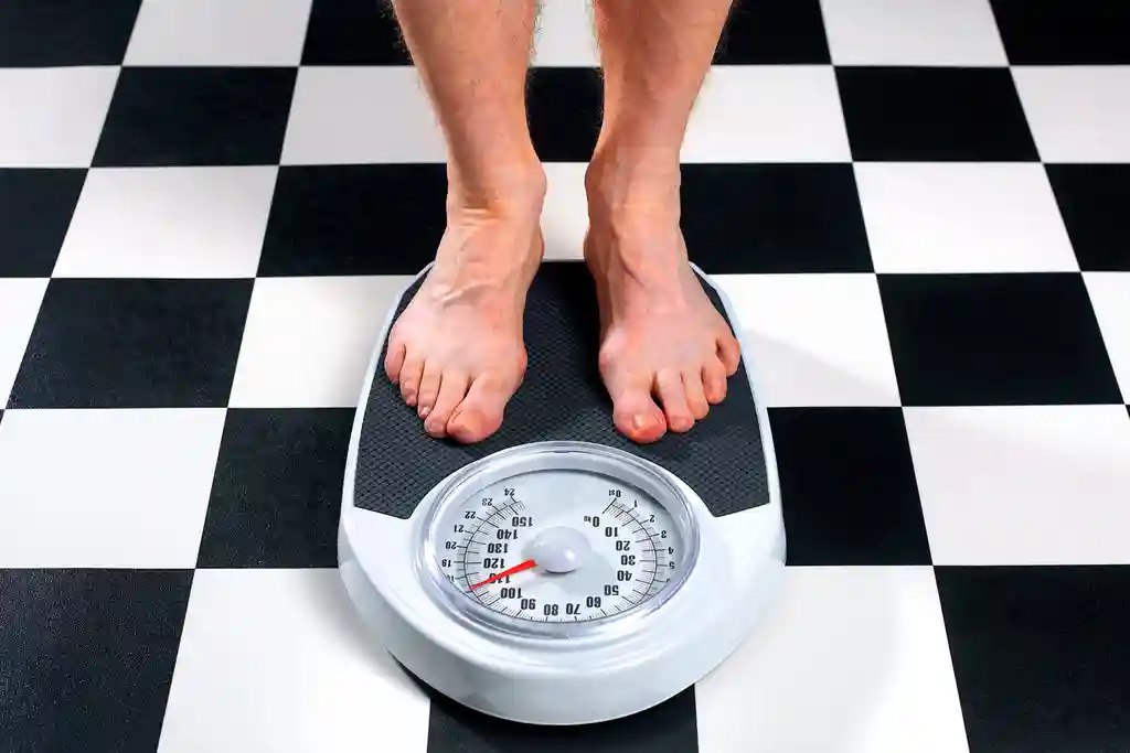 photo of overweight man standing on bathroom scale