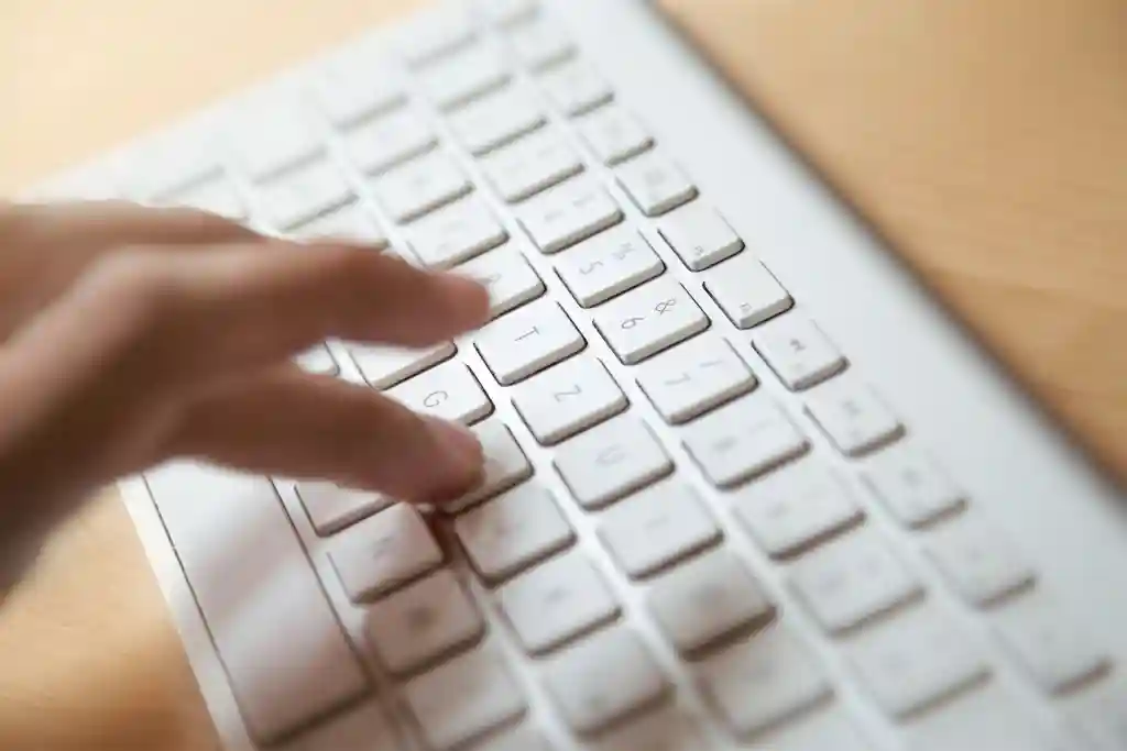 photo of close-up of hands typing on a keyboard