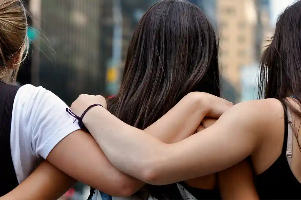 photo of female friends w/ arms around each other