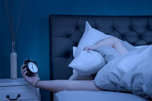 tired person holding alarm clock